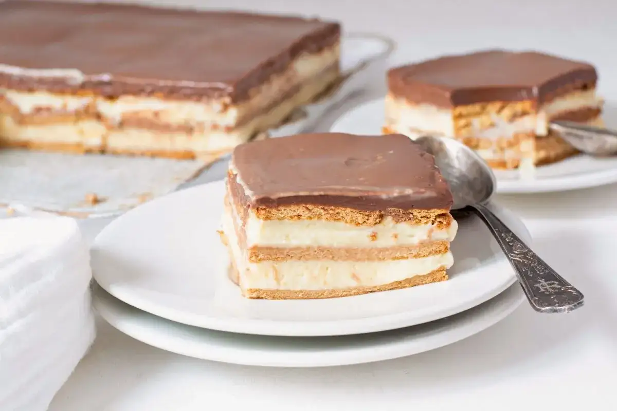 Una porción de tarta de la abuela, con capas de galleta y crema, cubierta de chocolate.