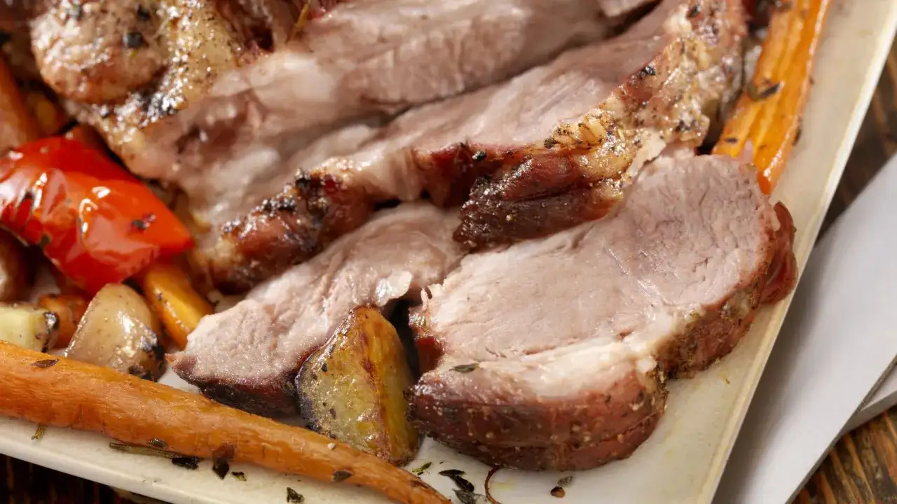 Jugoso solomillo de cerdo asado, acompañado de zanahorias tiernas y patatas doradas.