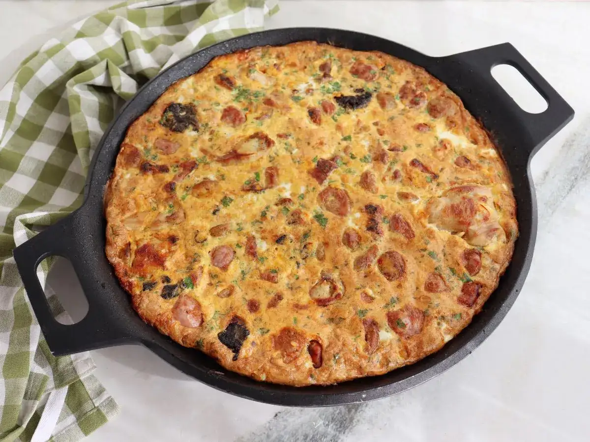 Arroz con costra reci&eacute;n hecho en sart&eacute;n negra, con trozos de salchicha y perejil picado.