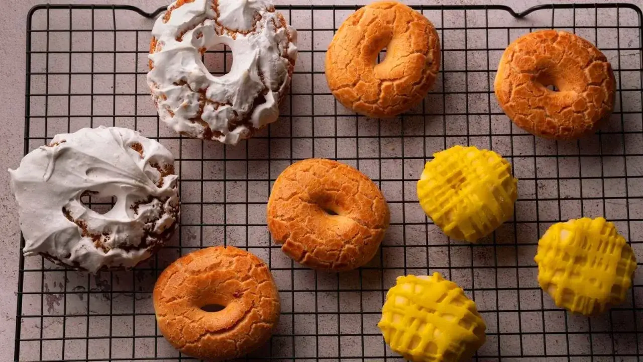 Rosquillas de San Isidro: dulces tradicionales con merengue blanco y glaseado amarillo, listos para disfrutar.