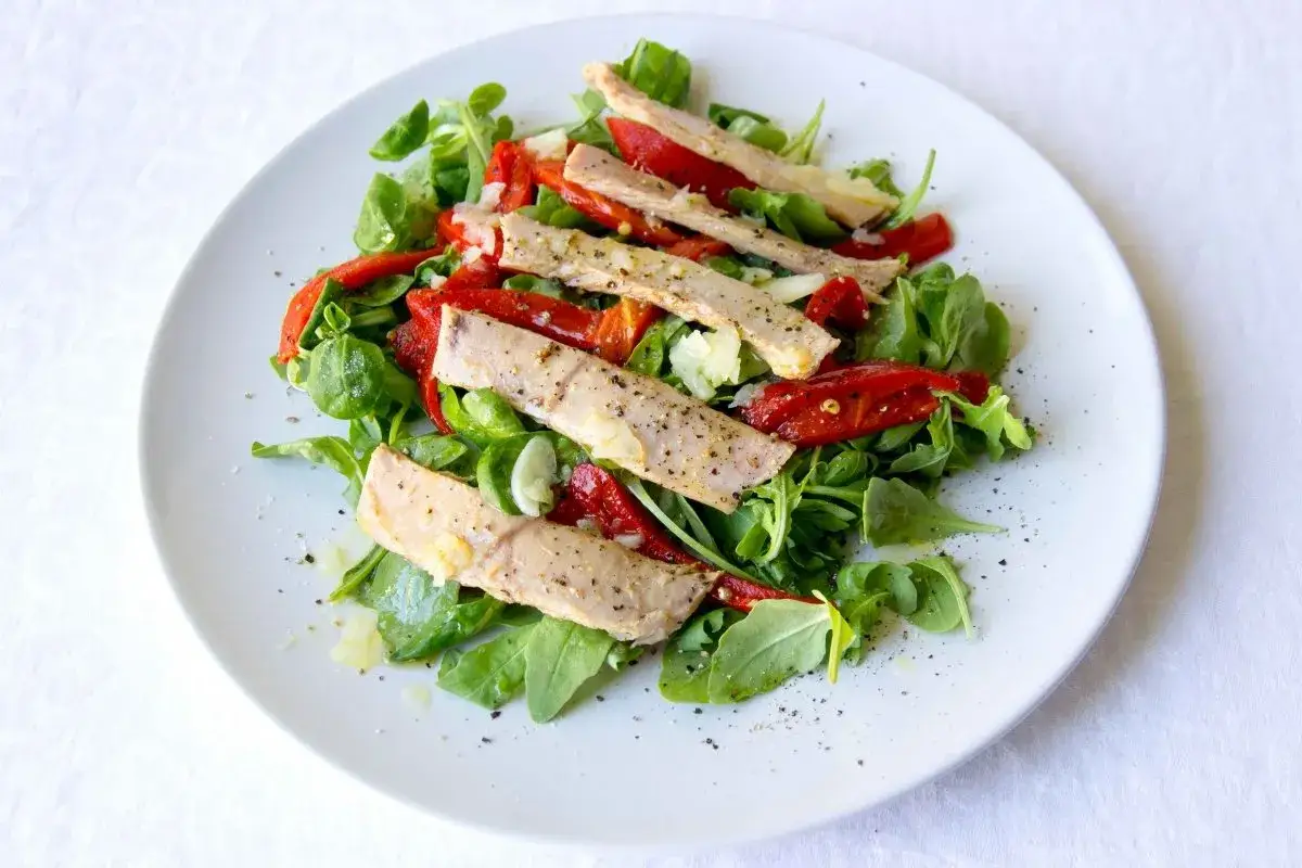 Deliciosa ensalada de ventresca con pimientos asados y r&uacute;cula, aderezada con aceite de oliva y pimienta negra.