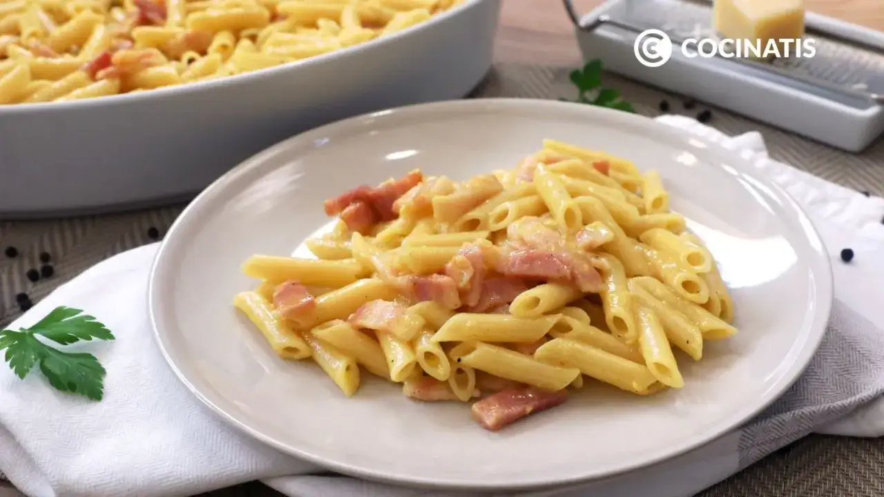 Un plato de macarrones a la carbonara cremosos, con trozos de panceta y un toque de perejil.