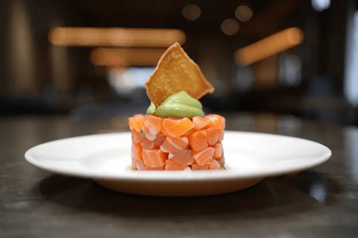 Delicioso tartar de salm&oacute;n fresco, coronado con aguacate cremoso y una crujiente tostada.