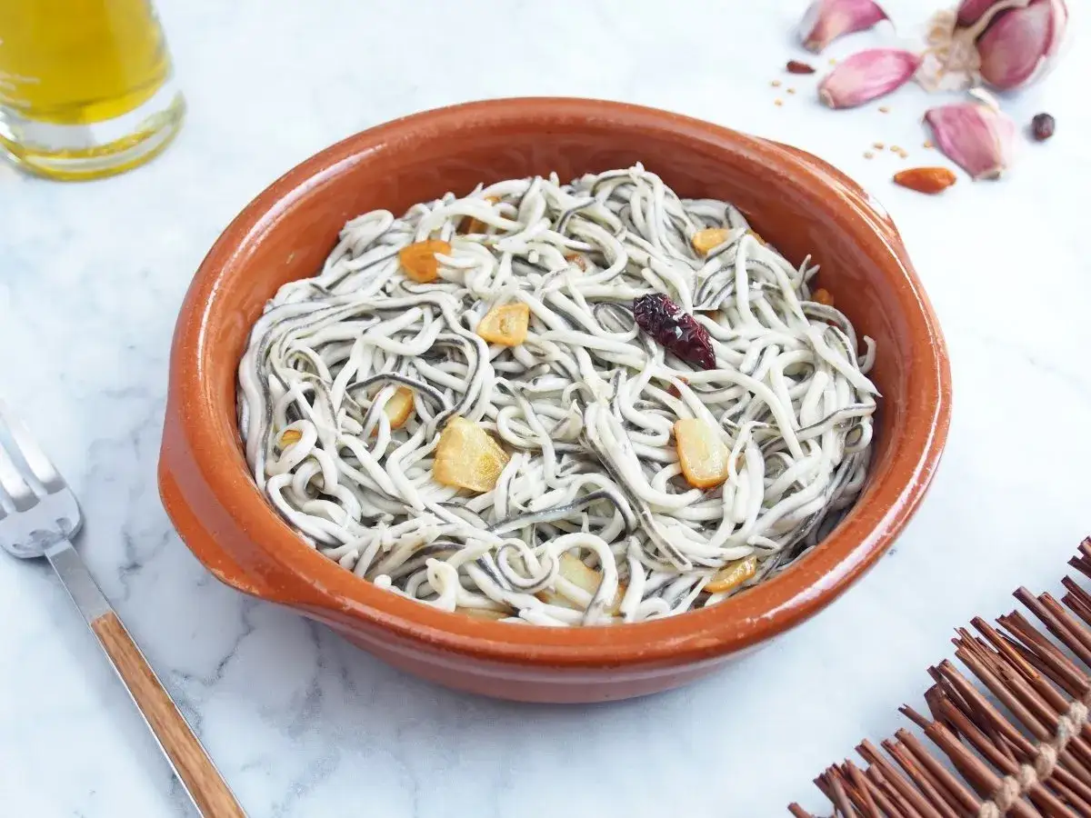 Un cuenco de barro con gulas al ajillo, salteadas con ajo y guindilla. Un plato típico español listo para disfrutar.