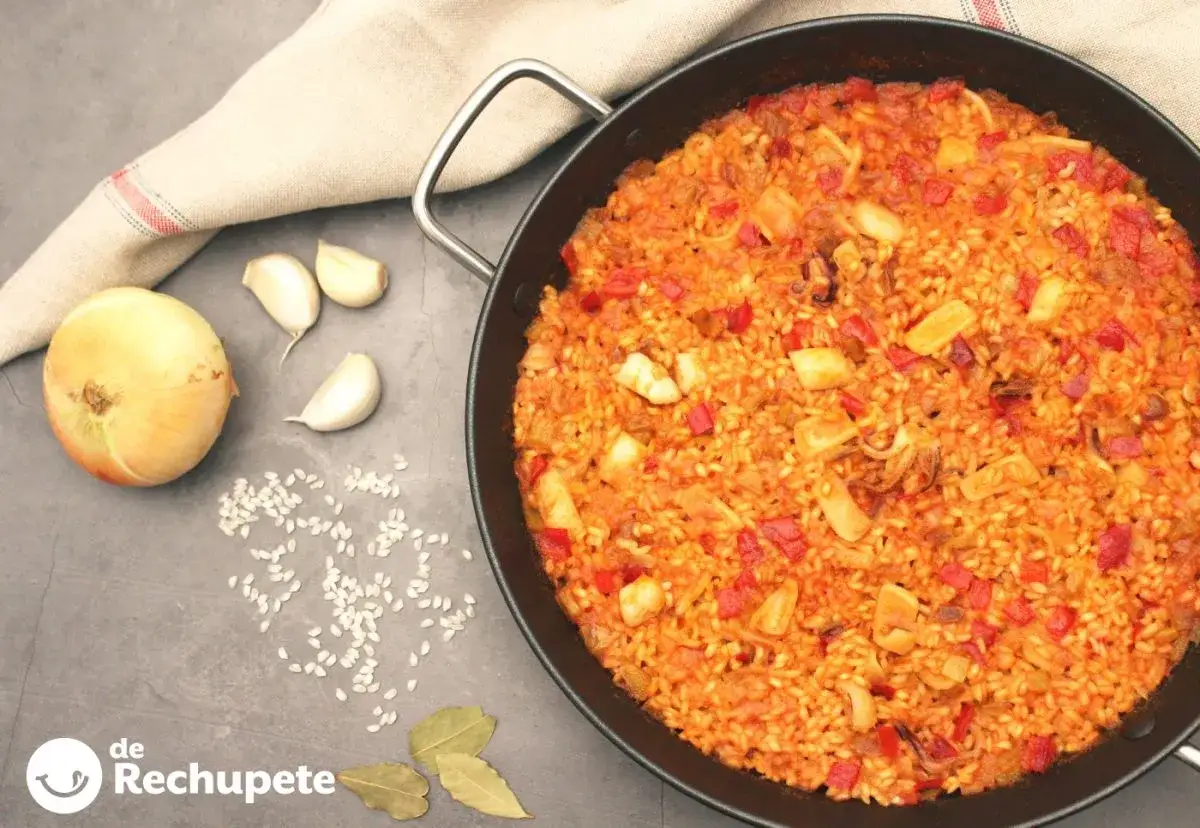 Arroz con calamares reci&eacute;n hecho en paellera, con ingredientes como cebolla, ajo y pimientos. &iexcl;Un plato delicioso!