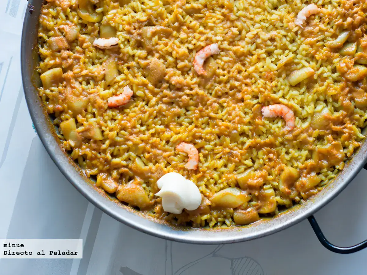 Arroz a banda en paellera, con gambas y trozos de pescado. Un plato delicioso y lleno de sabor.