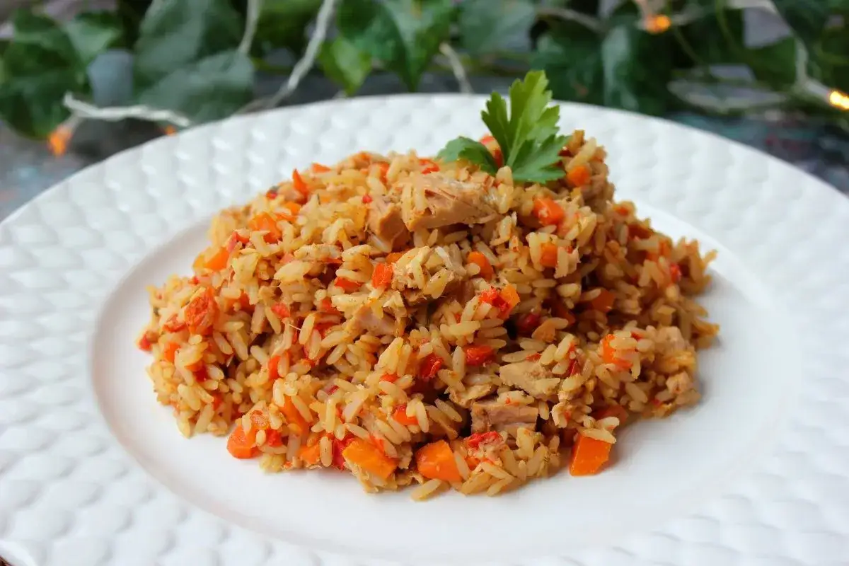Arroz con at&uacute;n, zanahoria y pimiento rojo, decorado con perejil. Un plato casero y delicioso.