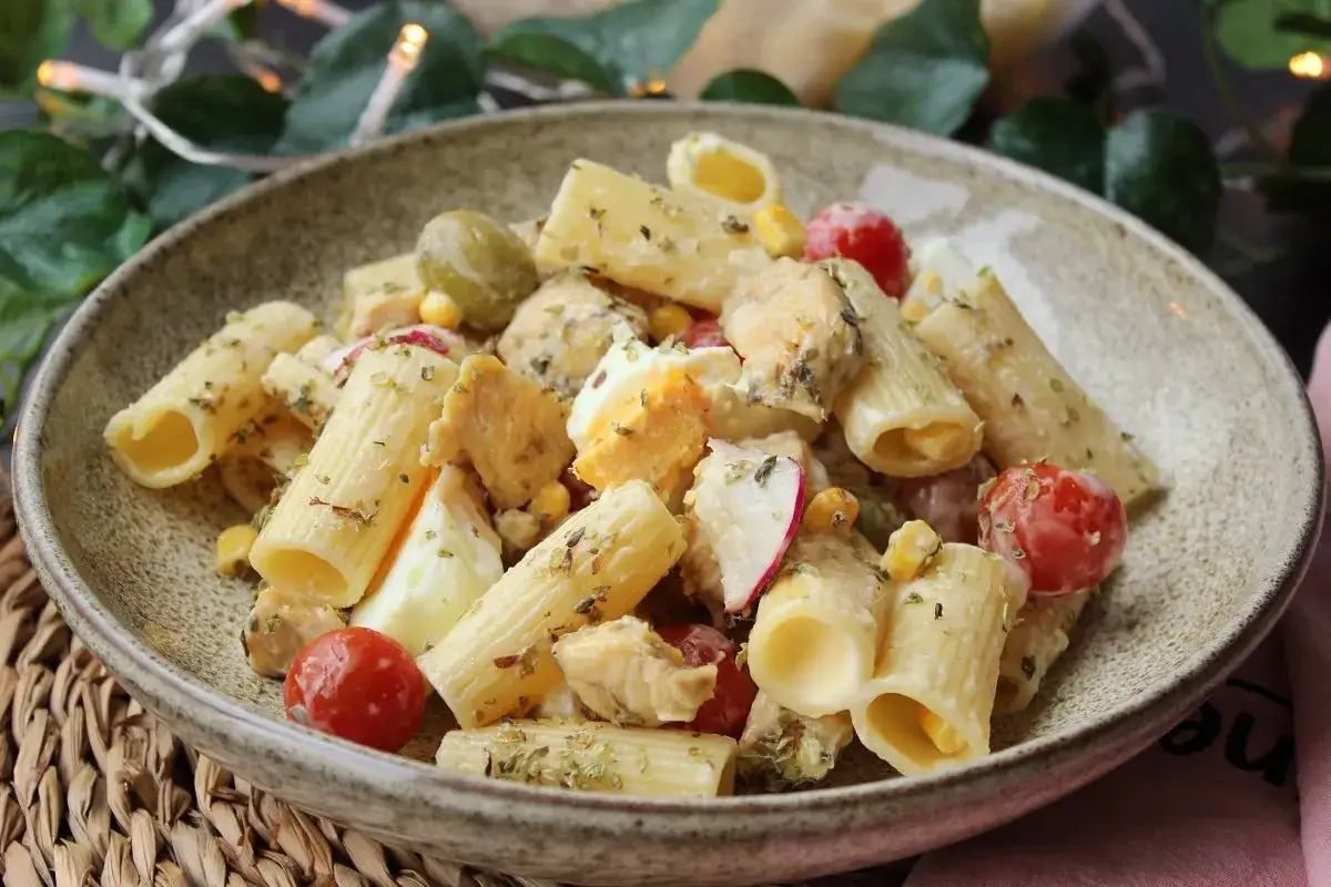 Deliciosa ensalada de pasta con pollo, huevo duro, tomates cherry, aceitunas y ma&iacute;z, todo mezclado con una cremosa salsa.