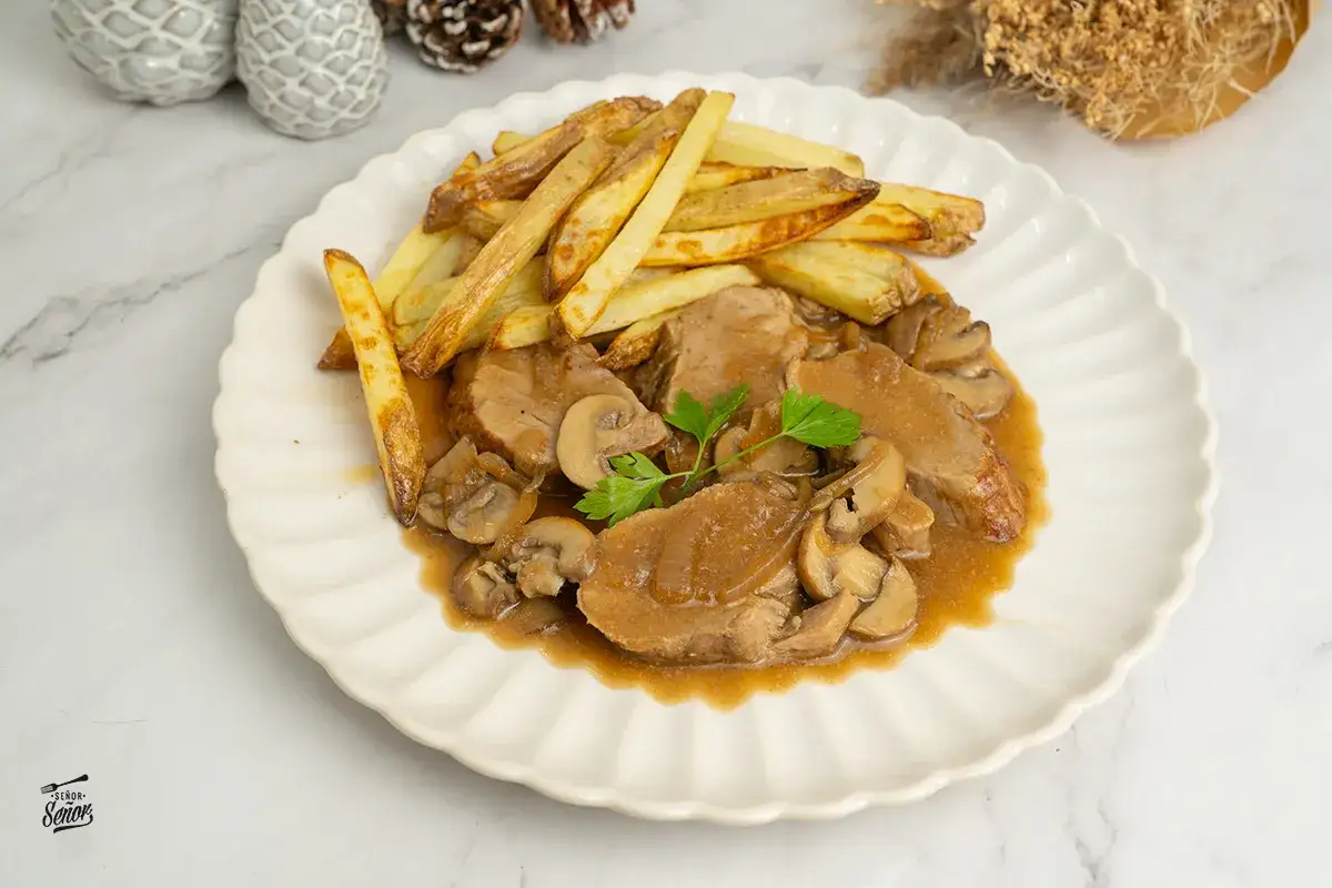 Solomillo en salsa de la abuela con patatas fritas, un plato casero que evoca recuerdos.