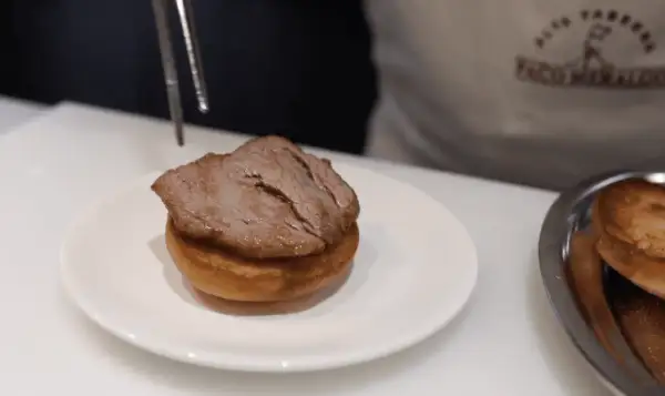 Un delicioso pepito de ternera, jugoso y tierno, listo para ser servido sobre un panecillo.