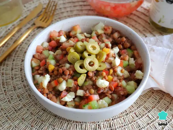 Ensalada de lentejas de bote con tomate, pepino, pimiento y queso fresco, coronada con aceitunas verdes. ¡Un plato fresco y nutritivo!