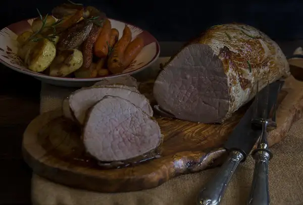 Jugoso redondo de ternera asado, servido con patatas y zanahorias. Un festín para los sentidos.