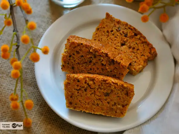 Rebanadas de tarta de zanahoria casera, esponjosas y con trocitos de zanahoria, servidas en un plato blanco.