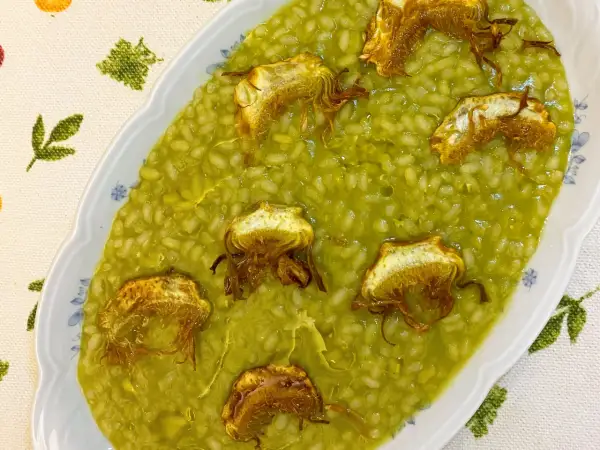 Arroz cremoso con alcachofas fritas, un plato delicioso y lleno de sabor.