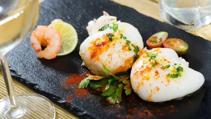 Deliciosa sepia en freidora de aire, servida con gambas, lima y tomates cherry.